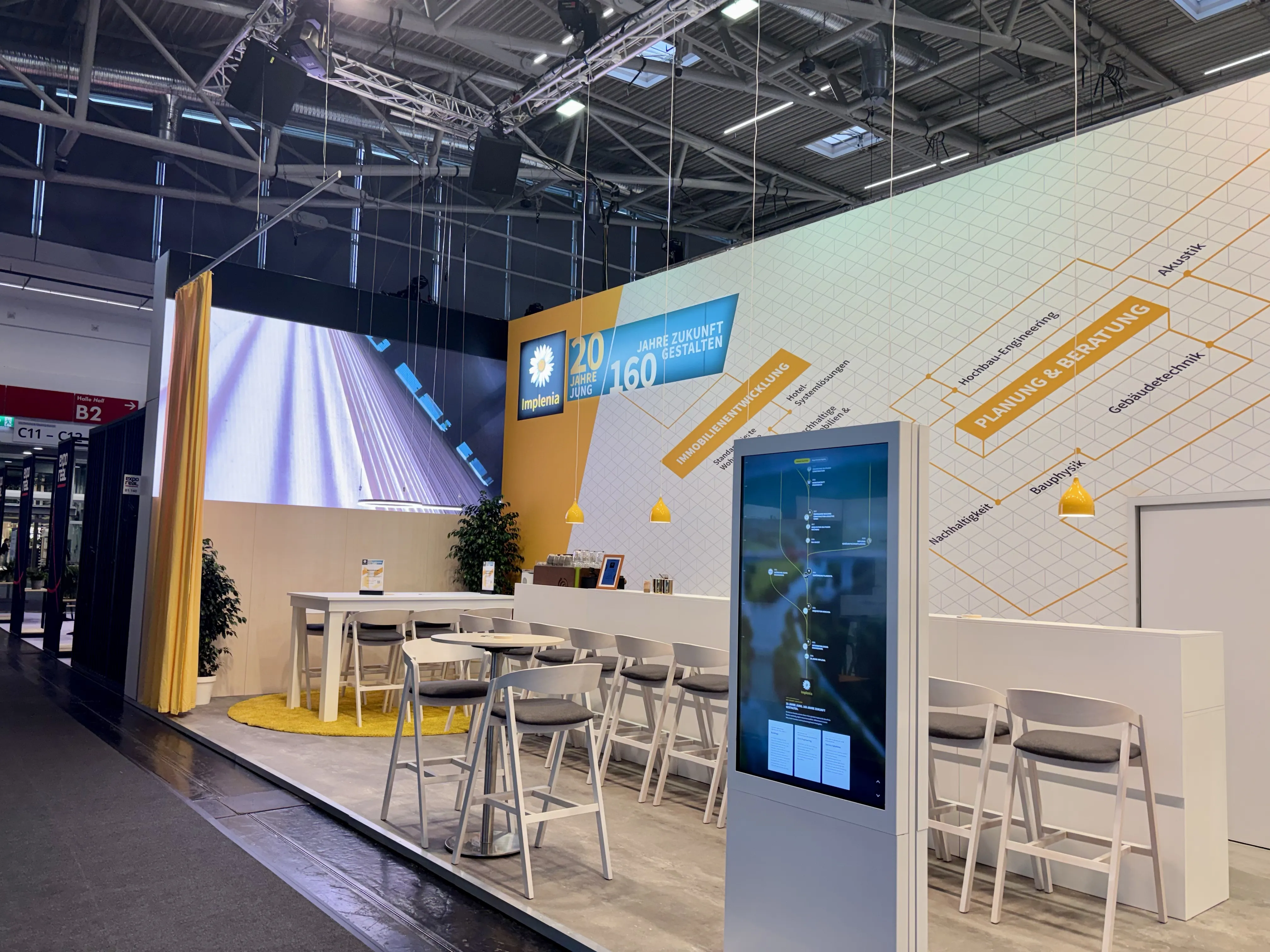 EXPO REAL 2026 in München: Messestand von Implenia mit digitaler Stele